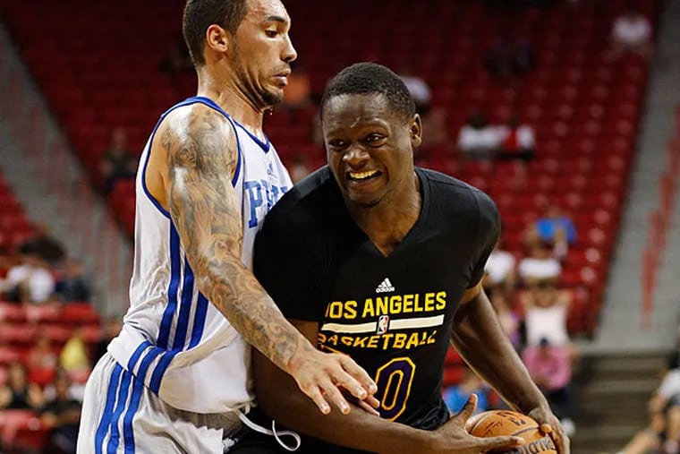 The Lakers' Julius Randle drives into Philadelphia 76ers' Drew Gordon during the first half of an NBA summer league basketball game Wednesday, July 16, 2014, in Las Vegas.