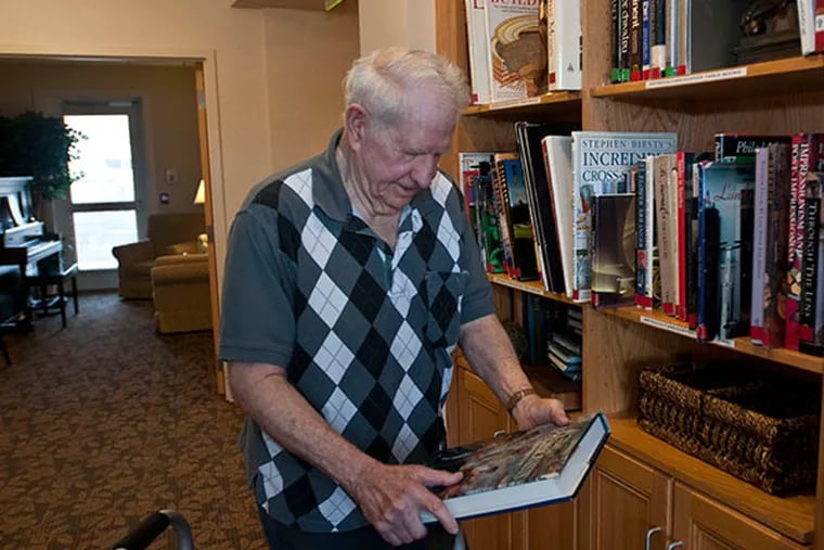 George Saurman checks out a book from one of the many libraries at Willow Brooke Court in Ft. Washington January 16, 2014. ( RON TARVER / Staff Photographer )