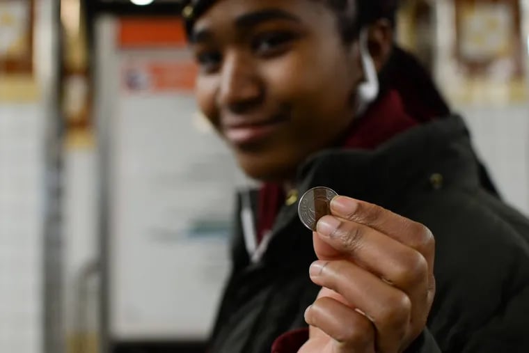 Lailani King, 16, holds up a token at the Spring Garden subway station on the Broad Street Line.
