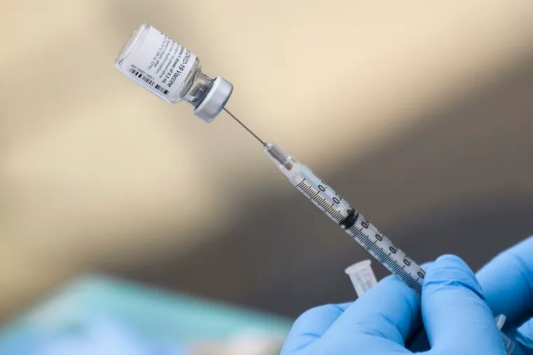 A syringe filled with the first dose of the Pfizer COVID-19 vaccine.