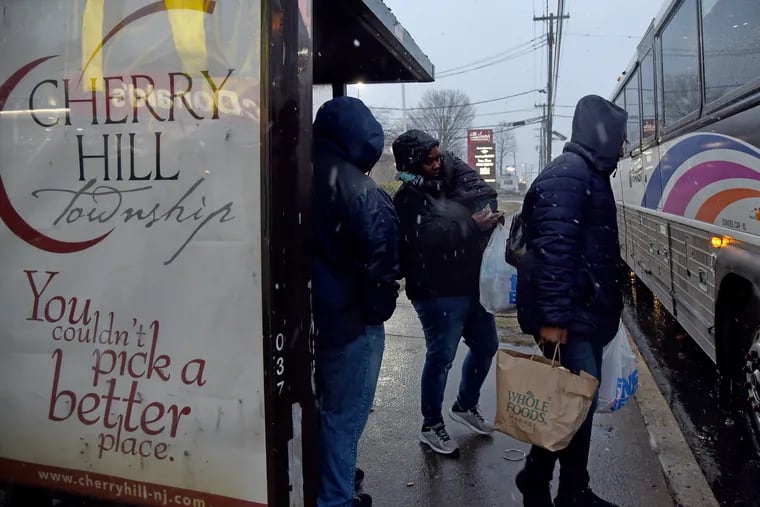 Shoppers get on the bus with their groceries as snow begins to fall at the Ellisburg Shopping Center on Route 70 in Cherry Hill.