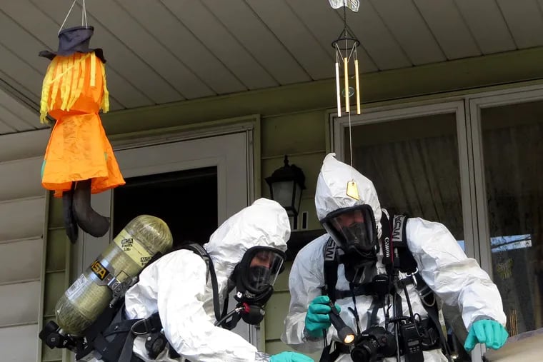 Members of the Pennsylvania State Police Clandestine Lab Response Team remove chemicals from the front porch of a home in Minersville in 2013.