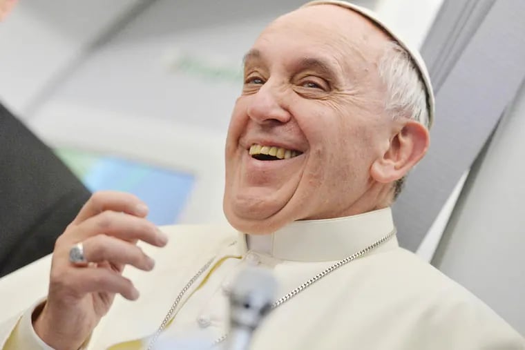 Pope Francis smiles as he answers reporters questions during a news conference aboard the papal flight on the journey back from Brazil, Monday, July 29, 2013. (Associated Press)
