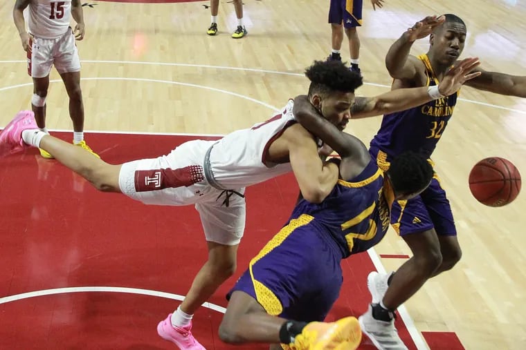 Arashma Parks, left, of Temple gets fouled by Tremont Robinson-White, center,  of East Carolina during the 2nd half at the Liacouras Center on Feb. 1, 2020.  It was ruled a flagrant foul. Charles Coleman is right.