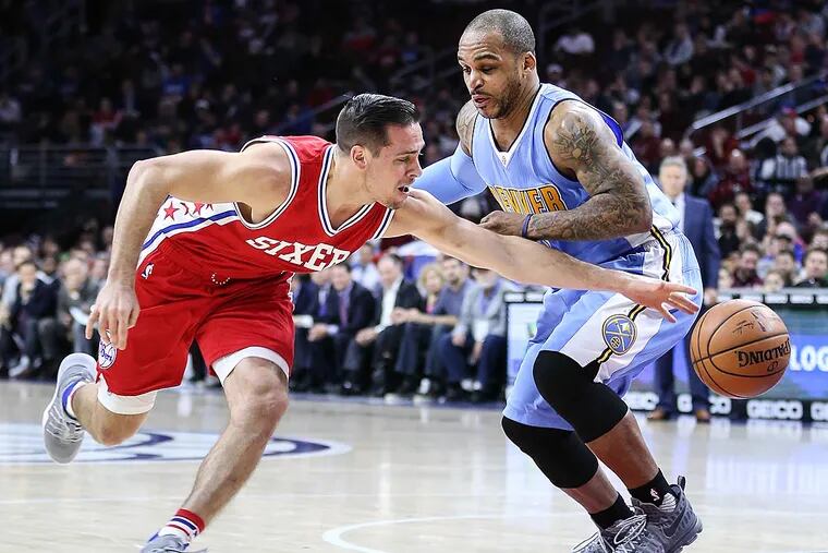 T.J. McConnell reaches for a loose ball against the Nuggets' Jameer Nelson.