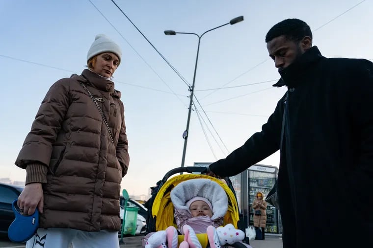 Emile Nkoyok and his wife, Agniia Nkoyok, stand outside a metro station in Kharkiv, Ukraine, with their 5-month-old daughter, Emily-Grace, in case they need to take shelter again after explosions were heard in the city on Feb. 24. The violence in Ukraine may be difficult for caregivers in the U.S. to discuss with children, but child development experts say it's important to give children an opportunity to share feelings and ask questions.