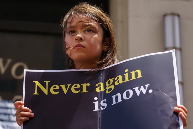 Seven-year-old Amalia Pintor holds a sign during a protest outside the ICE office in Philadelphia last year. People gathered on Lights for Liberty international day of protest against the treatment of migrant children being held in U.S. detention facilities.