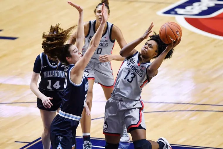 Connecticut's Christyn Williams, right, goes up for a basket as Villanova's Maddy Siegrist, front left, defends during the first half of an NCAA college basketball game in the Big East tournament semifinals at Mohegan Sun Arena, March 7, 2021, in Uncasville, Conn.