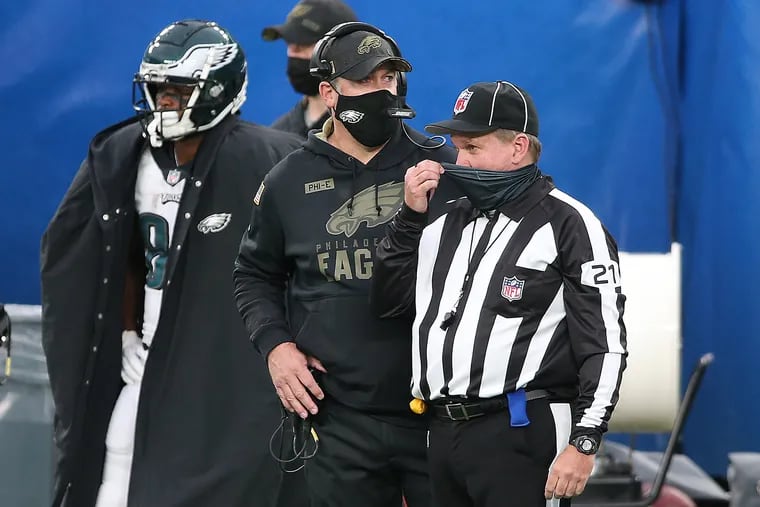 Eagles head coach Doug Pederson (left) talks with side judge Jeff Lamberth (right) during the second quarter as the Philadelphia Eagles play the New York Giants at MetLife Stadium in East Rutherford, N.J., on Sunday.