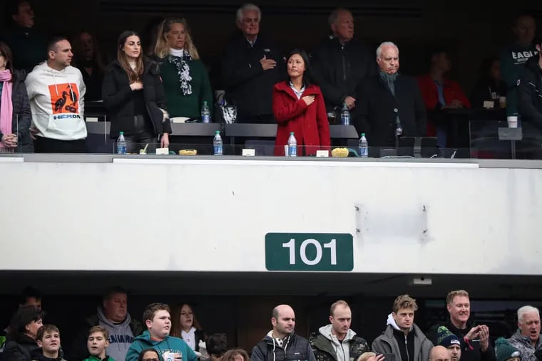 Eagles owner Jeffrey Lurie (right) and his wife, Tina Lai Lurie, stand in the owners box during the national anthem at an Eagles' game last November.