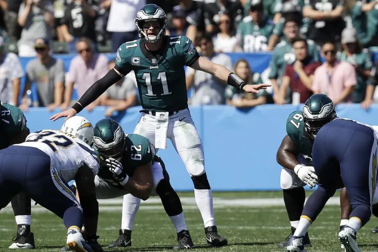 Eagles quarterback Carson Wentz signals with offensive linemen guard Brandon Brooks, Jason Kelce and Chance Warmack against Los Angeles Chargers nose tackle Brandon Mebane on Sunday, October 1, 2017 in Carson, CA. YONG KIM / Staff Photographer
