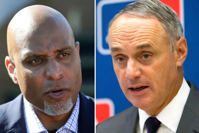 MLBPA executive director Tony Clark, left, and MLB commissioner Rob Manfred have differing opinions about when spring training should begin.