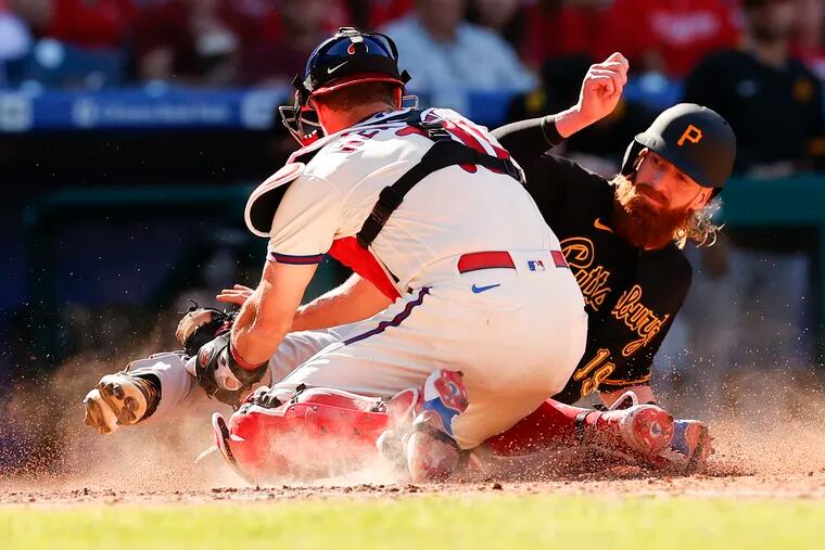 Phillies catcher J.T. Realmuto tugs out the Pirates' Colin Moran at home during the seventh inning on Sunday.
