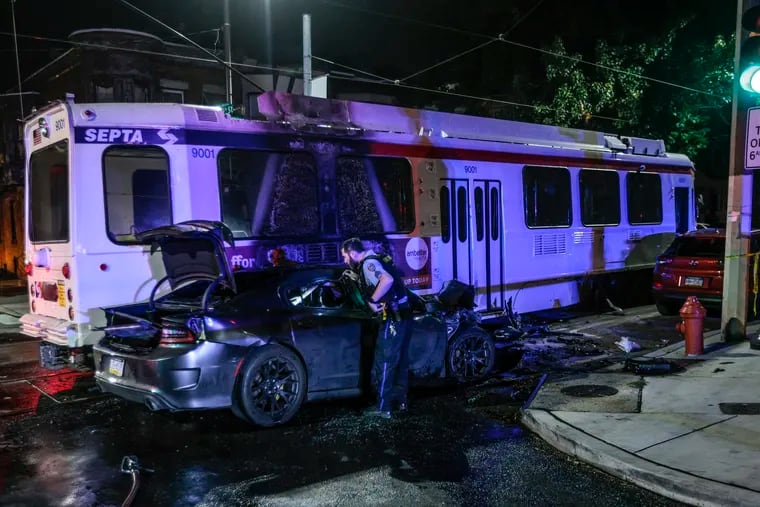 Police investigate the scene at 59th Street and Lansdowne Avenue where a Dodge Charger collided with a SEPTA trolley Thursday, Sept. 21, 2023.