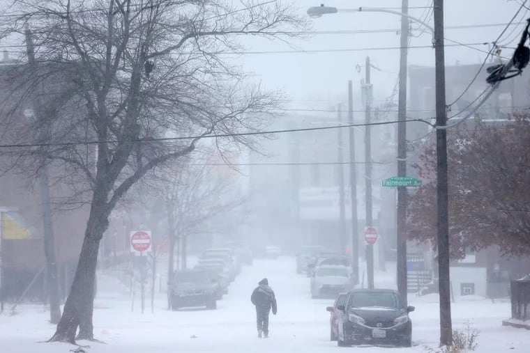 A man walks down North Preston Street in West Philadelphia as snow falls on Thursday, Jan. 4, 2017.