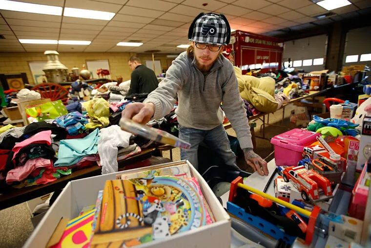 Steven Whitfield sorts toys and other donated items at a firehouse. His wife, Stefanie, began collecting items at their home the morning of the blaze, but soon ran out of space. The couple accepted an offer to have the firehouse host the effort.