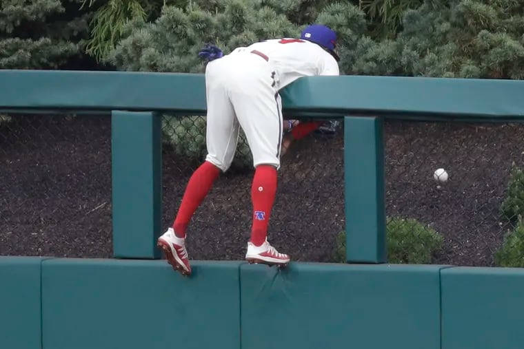 Phillies Roman Quinn hangs on the center field railing after Cardinals Paul DeJong hit a solo home run.