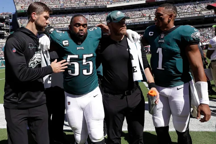 Eagles quarterback Jalen Hurts checking on defensive end Brandon Graham (55) after Graham came off the field with an injury on Sept. 19.