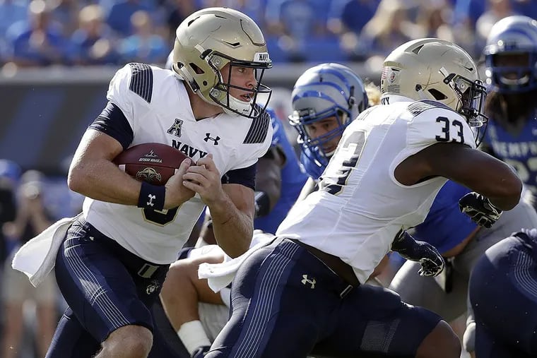 Navy quarterback Zach Abey, left, runs the ball behind the blocking of fullback Chris High (33) in the first half of an NCAA college football game against Memphis Saturday, Oct. 14, 2017, in Memphis, Tenn.