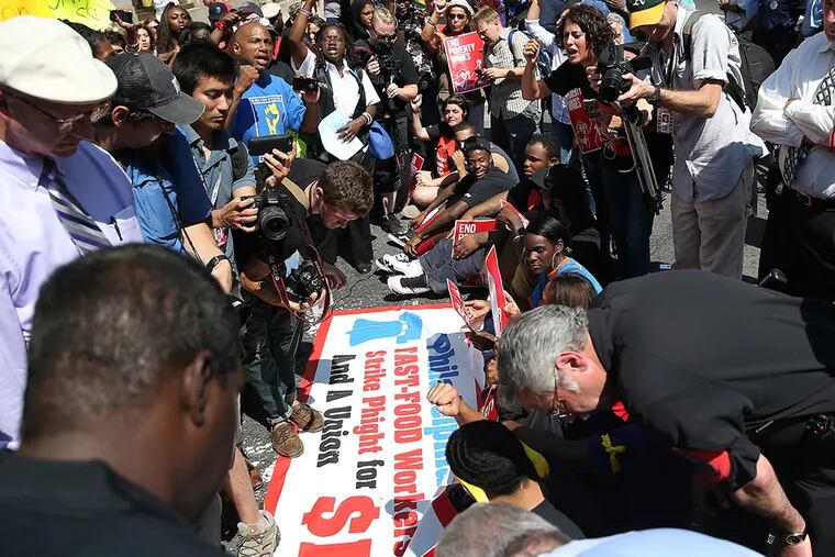 Police move in to make arrests during a protest for higher wages at fast-food restaurants in Philadelphia on September 4, 2014. Protesters were arrested after they refused to move from the intersection of Broad and Arch streets. ( DAVID MAIALETTI / Staff Photographer )