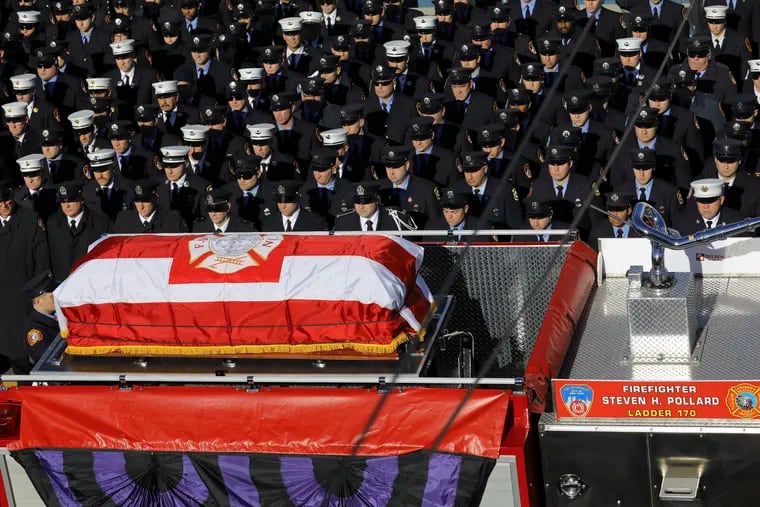 Fallen firefighter Steven Pollard's casket is driven on his firehouse truck through a roadway lined with thousands of firefighters Friday Jan. 11, 2019, in New York. The 30-year-old was assigned to Ladder 170 of the Fire Department of New York when he was fatally injured last Sunday on Brooklyn's Belt Parkway.