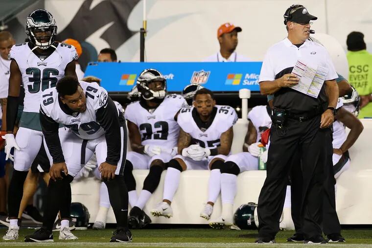 Eagles head coach Doug Pederson (right) and some players watch from the sideline during the preseason game against the Ravens.