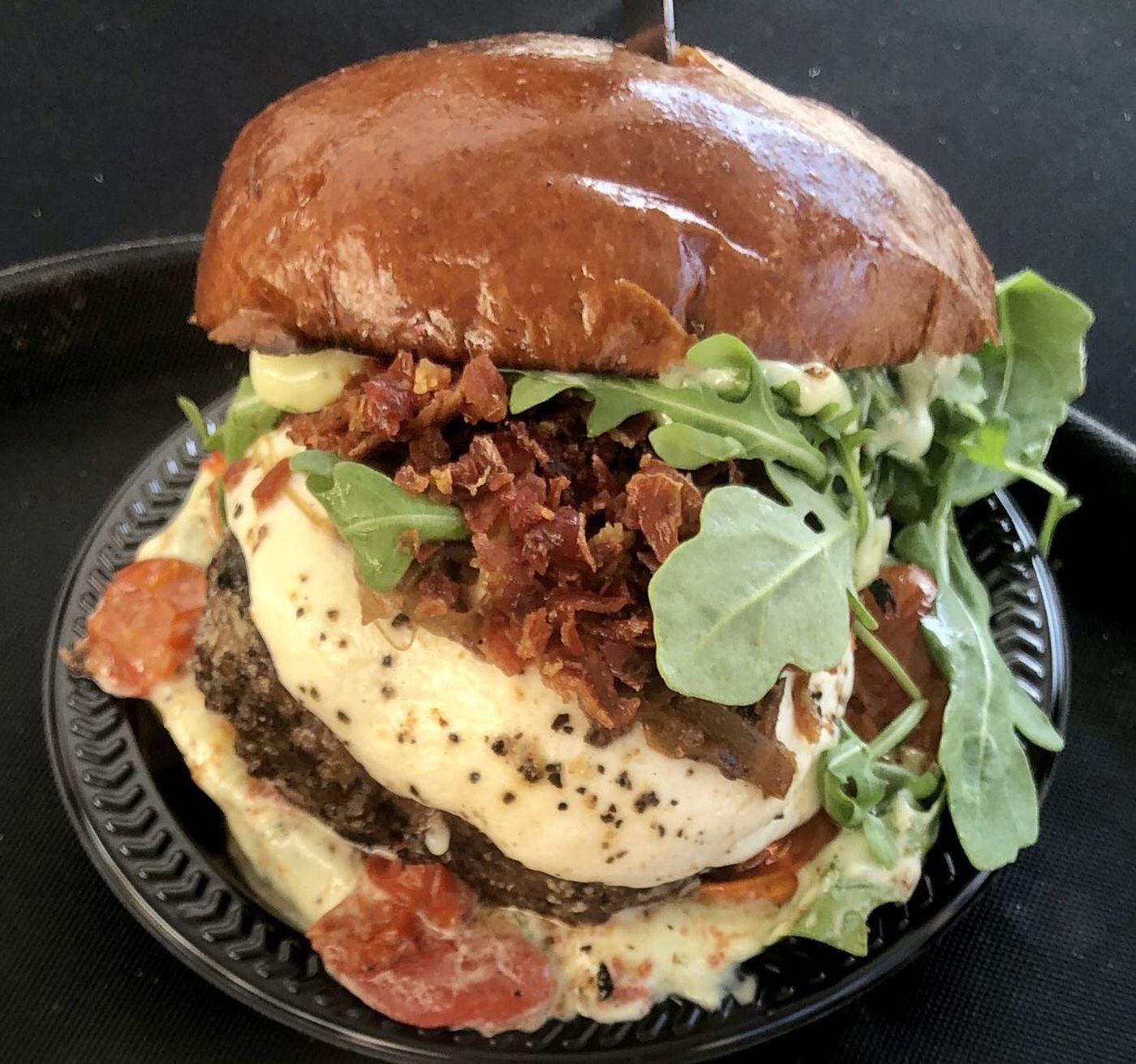 The Pennsport from Moonshine was topped with crispy prosciutto, mozzarella, caramelized onions, basil aioli, arugula, and tomato jam on a garlic-toasted bun.