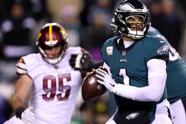 Philadelphia Eagles quarterback Jalen Hurts (right) looks to pass while Washington Commanders defensive lineman Casey Toohill applies pressure during Monday night's game at Lincoln Financial Field. Hurts and the Eagles fell 32-21, their first loss of the season. (Photo by Scott Taetsch/Getty Images)