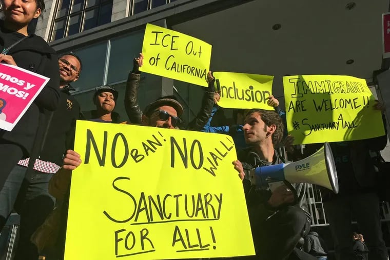 Protesters rally outside a courthouse where a federal judge heard arguments in the first lawsuit challenging President Donald Trump’s executive order to withhold funding from communities that limit cooperation with immigration authorities in San Francisco.