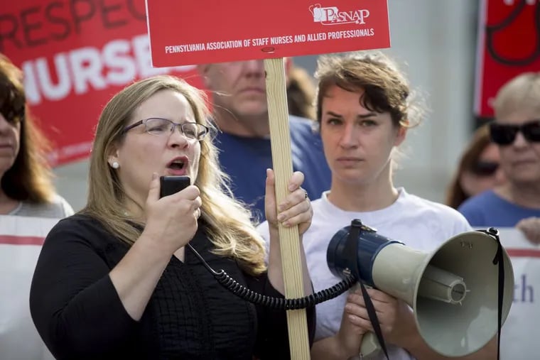 Tammy Christiansen, center, a nurse at Delaware County Memorial Hospital, spoke as nurses, their supporters, and union members rallied outside the Delaware County courthouse in Media, Wednesday.