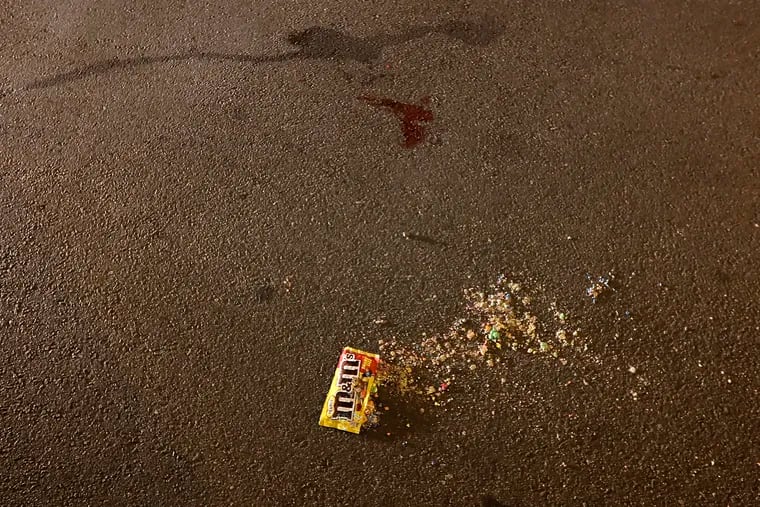 Blood and M&M’s are what is left in the road after a young girl possibly in her early teans was shot and killed by random gunfire when she got off a bus at 22nd and Sedgley in Phila., Pa, around 4:30 pm on November 30, 2019.