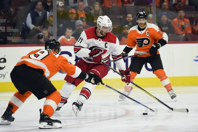 Hurricanes’ Jordan Staal, center, looks to pass the puck as Flyers’ defenseman Ivan Provorov, left, defends during the first period of the Flyers’ 4-1 loss on Thursday.