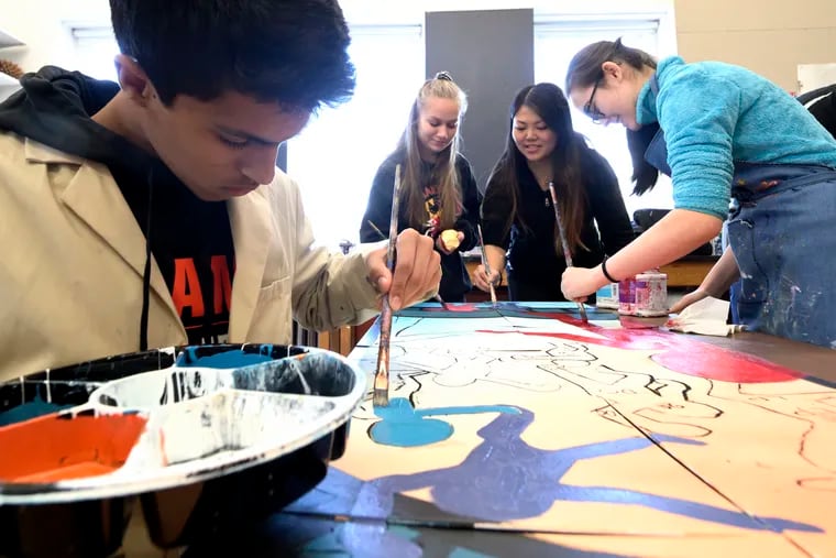 (Left to Right) Sophomore Arjun Ratnakar, Senior Ivy Hunnicut, Teacher Ada Cheung and Senior Isabel Kinsman work together on a Keith Haring-inspired mural.