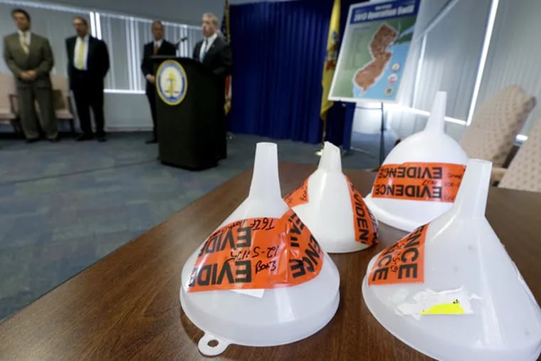 Funnels confiscated during an investigation dubbed "Operation Swill," in which 29 bars and restaurants in New Jersey are accused of putting cheap booze in premium brand liquor bottles and selling it, are displayed during a news conference, Thursday, May 23, 2013, in Trenton, N.J. Thirteen of the restaurants cited are TGI Fridays located in central and northern New Jersey. (AP Photo/Julio Cortez)