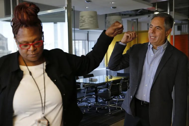 Evelyn Parker, a case worker who was formerly incarcerated, and Richard Cohen, president and CEO of the Philadelphia Health Management Corp., fist-bump after talking in their office in Philadelphia.