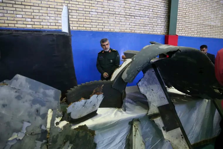 Head of Iran's Revolutionary Guard's aerospace division Gen. Amir Ali Hajizadeh looks at debris from what the division describes as the U.S. drone which was shot down on Thursday, in Tehran, Iran.