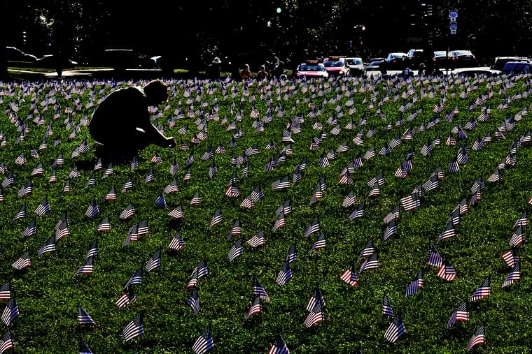 American flags are planted on a grassy area of the National Mall in Washington, D.C., each of them representing a veteran or service member who died by suicide in 2018.