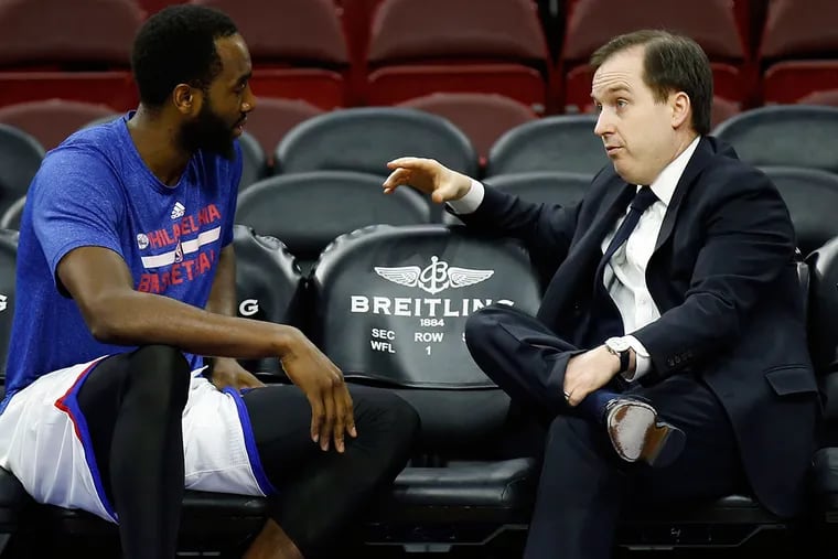 Sam Hinkie talks with forward Luc Mbah a Moute during pregame warmups Jan. 28, 2015 in Philadelphia.