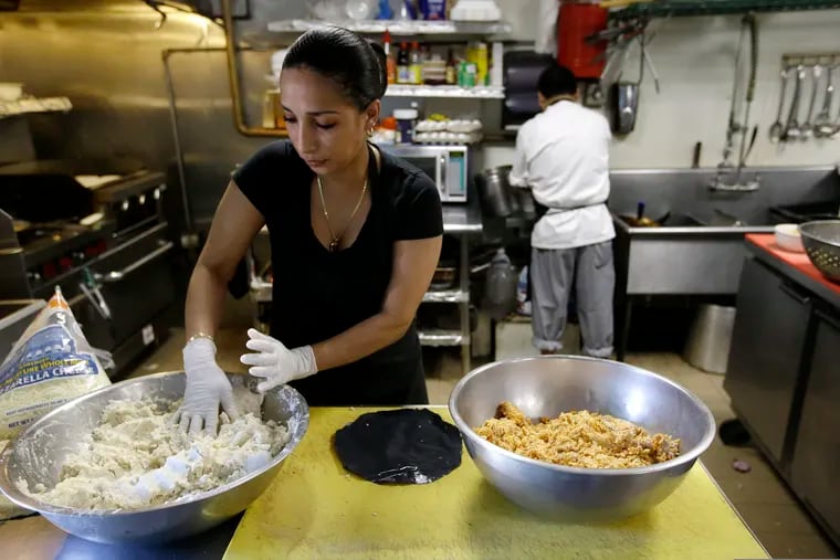 In June, Mariana Moncada, left, originally of Honduras, prepares food in a kitchen, in Chelsea, Mass. The number of Central Americans in the United States has increased over the last decade, and Chelsea has exemplified that trend with a population that is more than 60 percent Latino.