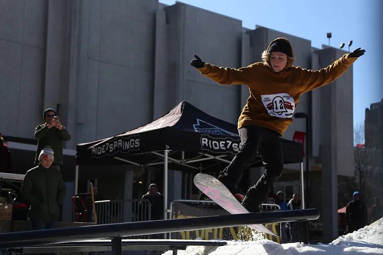 A snowboarder hits a rail during warmup runs before the start of a competition at Temple University on Friday, Feb. 13, 2015.  The makeshift course was placed in the middle of campus.  (Andrew Thayer / Staff Photographer)