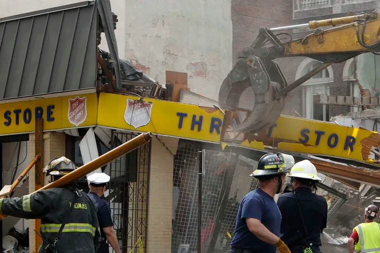 Workers take down what remains of the Salvation Army thrift store at 22d and Market Streets. All six victims were found on the first floor.