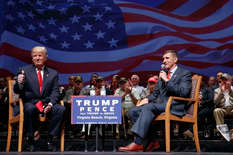 Then-presidential candidate Donald Trump gives a thumbs up as he speaks with retired Lt. Gen. Michael Flynn during a town hall, Tuesday, Sept. 6, 2016, in Virginia Beach, Va. President Donald Trump has pardoned Michael Flynn, taking direct aim in the final days of his administration at a Russia investigation that he has long insisted was motivated by political bias.
