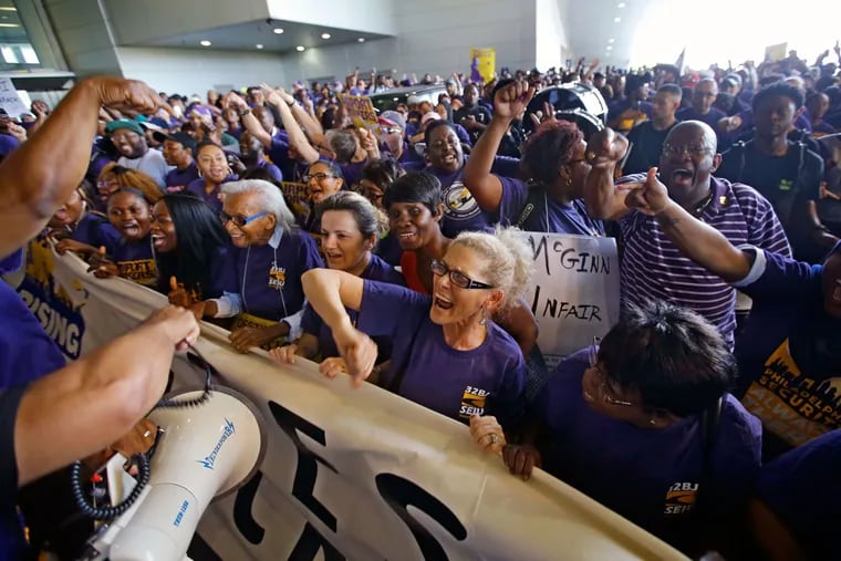 Virginia Gomez (center), along with an etimated crowd of 600 Service Employees International Union members, gets fired up in front of Terminal A at the Philadelphia International Airport on Tuesday, July 19, 2016.