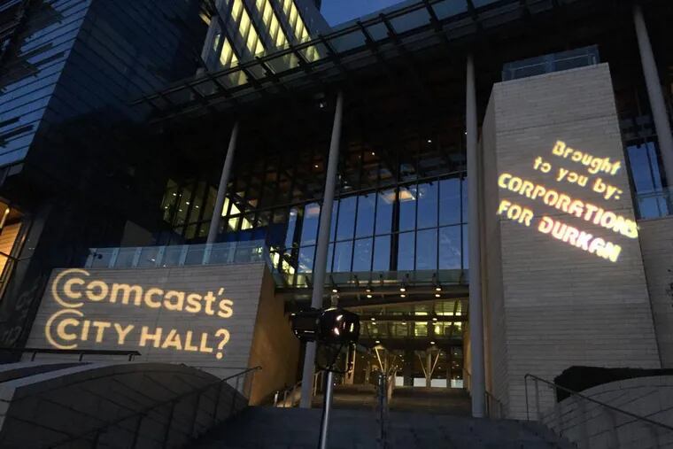 Activists in Seattle renamed the city’s municipal building as “Comcast’s City Hall” on Nov. 2 with lights during the mayoral campaign. They say Comcast and other telecom companies have derailed plans for a municipal broadband network.