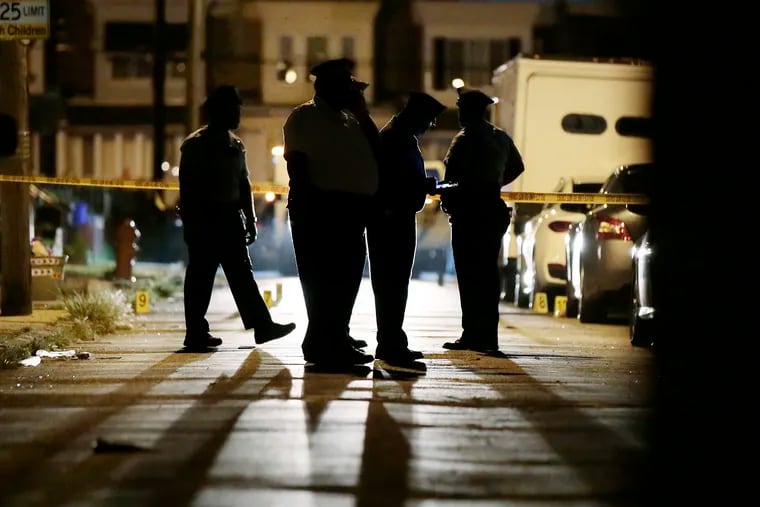 Philadelphia Police document a crime scene on the 2600 block of Carroll Street in Philadelphia where a 21-year-old man was killed and five others were injured in a drive-by shooting just after 8 p.m. on July 28, 2019.