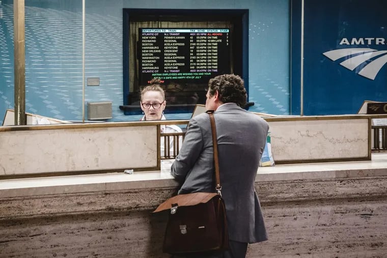 An Amtrak ticket agent helps a customer purchase at 30th Street Station.
