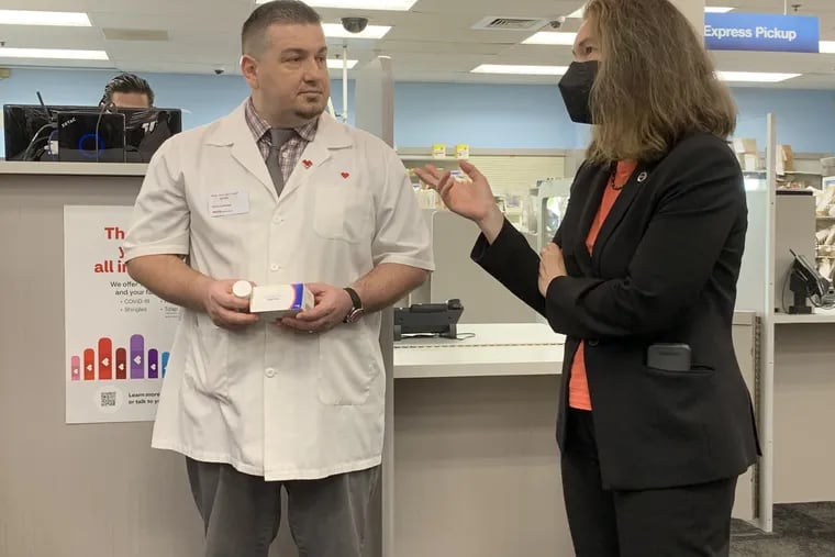 U.S. Health and Human Services Assistant Secretary Dawn O'Connell chats with Ervis Rrapi, pharmacy manager at the CVS on Harbison Avenue in Philadelphia, about access to antivirals needed to treat COVID-19.