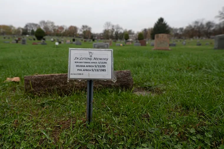 A view of the markers placed on the graves of three children killed in the MOVE bombing at the Eden Cemetery in Collingdale, Pa. The graves have been unmarked for decades until the recent installations of temporary markers.