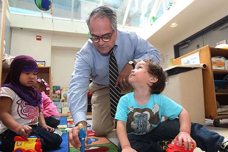 Stan Retif, center, a fundraiser at EducationWorks interacts with Brianna Witcher, 3, left, and Logan Pereira, 2, right, in the Early Learning Center at EducationWorks on April 28, 2014. ( MICHAEL BRYANT / Staff Photographer )