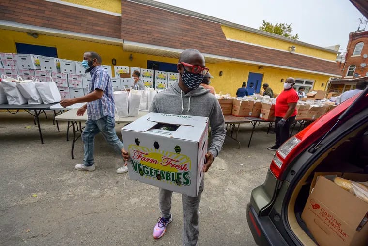 Voice of Praise Worldwide Ministries church member Terrill Haigler aka "Ya Fav Trashman" on Instagram, loads boxes into cars during a food drive at the North Philadelphia parish in October.